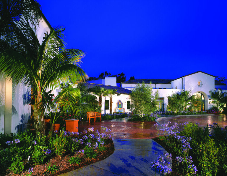 A serene courtyard adorned with palm trees and a beautiful fountain, creating a tranquil ambiance.