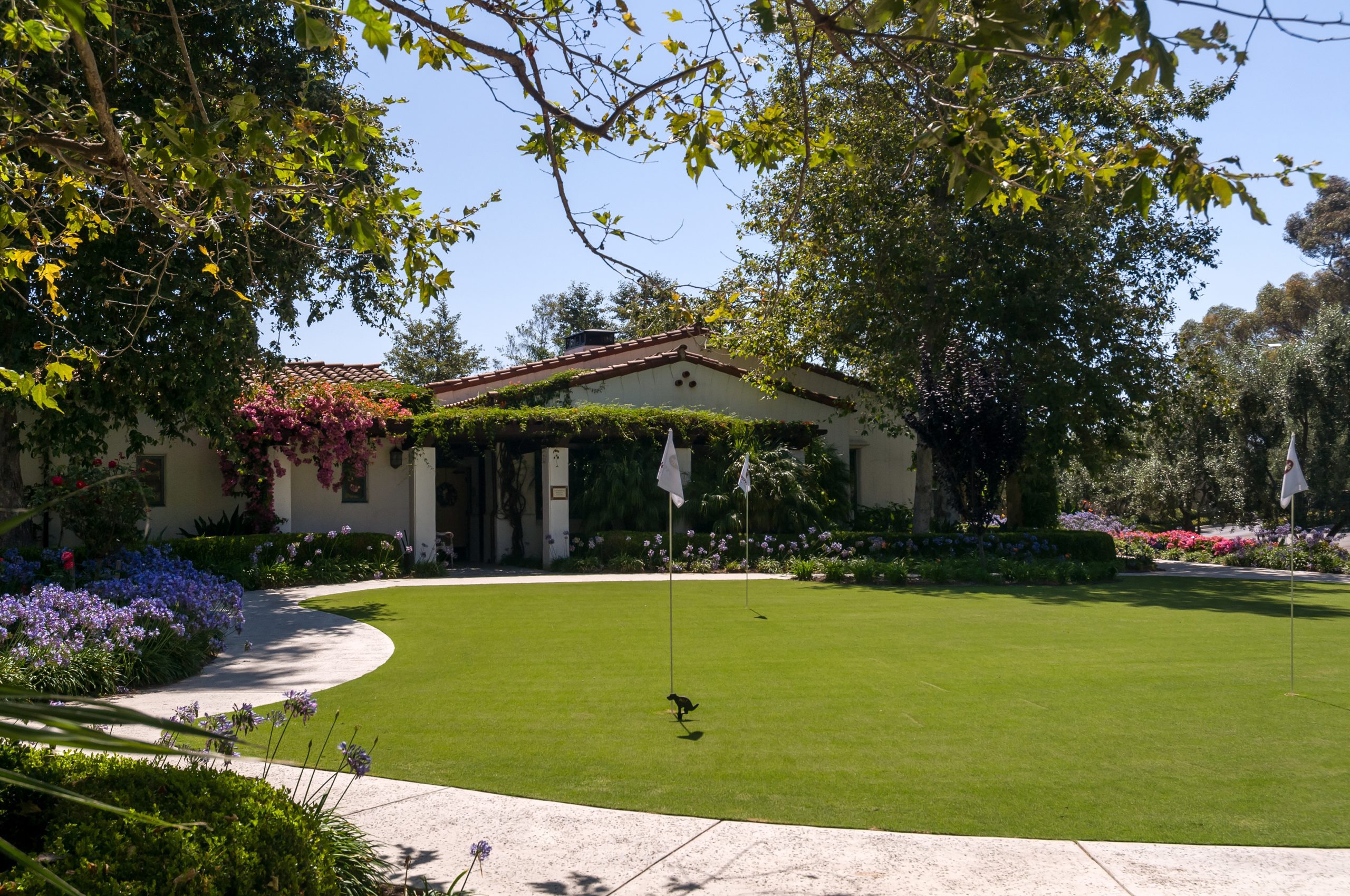 A picturesque home with a putting green and vibrant flowers, creating a serene and inviting atmosphere.