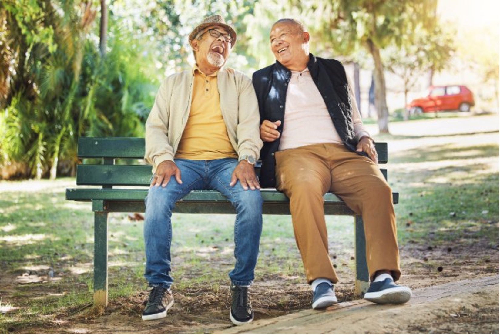 srg-cultivating Two men sitting on a bench in a park and laughing by Senior Resource Group