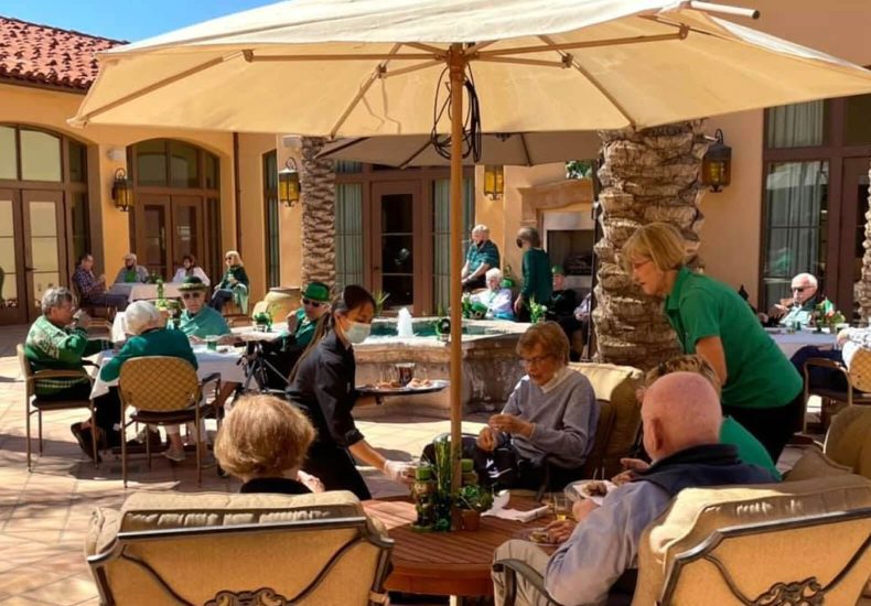 People enjoying outdoor dining at tables on a patio.