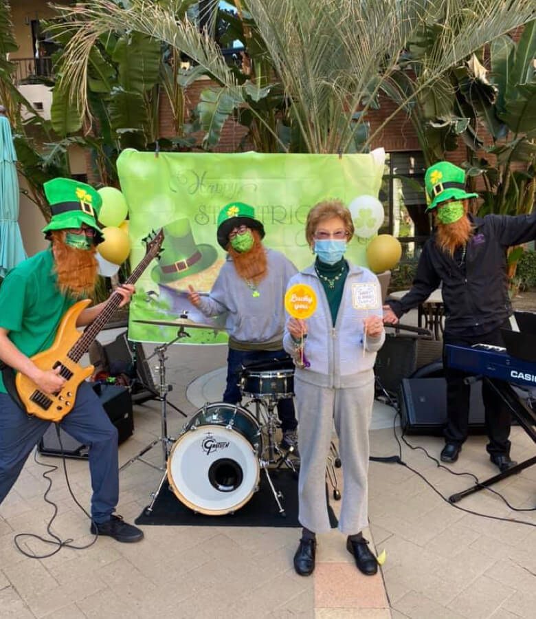 A group of people wearing green face masks and holding instruments for st patricks day, performing together.